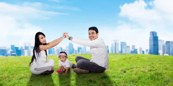 幸せな家族の父母と娘遊びで草原 — ストック写真