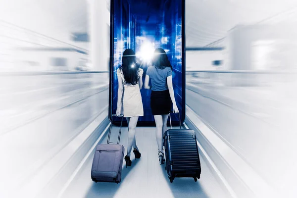 两个拿着手提箱走向一个大智能手机的女人 — 图库照片