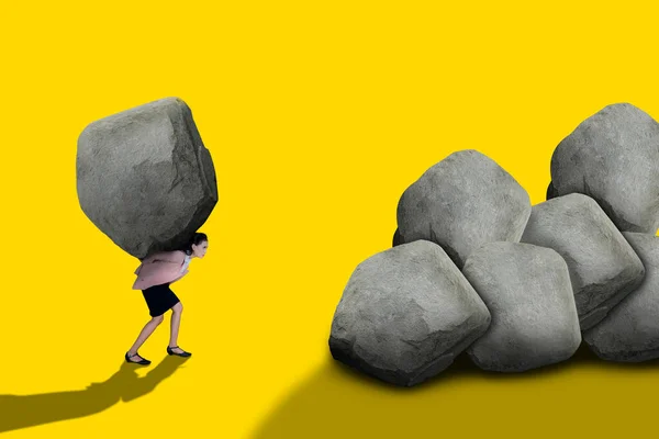 一位女商人举起一块巨大的岩石 在黄色的背景上与外界隔绝 — 图库照片
