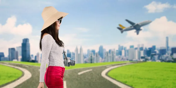 具有城市背景的女性旅行者和在城市上空飞行的飞机的服装 — 图库照片