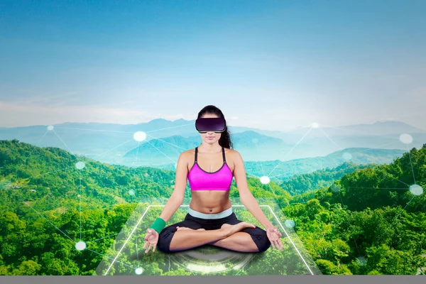 Young Athletic Woman Wearing Virtual Reality Headset, Practising Meditation in Modern Futuristic Way