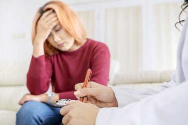 Kadın psikoloğun, klinikteki üzgün genç bir bayanla birlikte not aldığı bir dosya. Ruh sağlığı konsepti