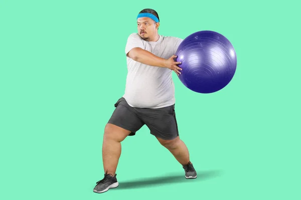 Υπέρβαρος Άνθρωπος Κάνει Άσκηση Γυμναστικής Μπάλα Pilates Απομονώνονται Πράσινο Φόντο — Φωτογραφία Αρχείου