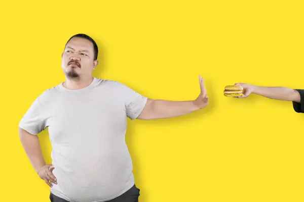 Overweight Asian Guy Refusing Hamburger Isolated Yellow Background Fast Food — Stock Photo, Image