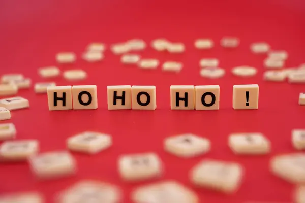 The word HOHOHO with wooden letter tiles isolated on red background