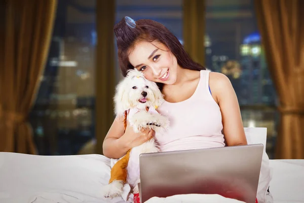 Krásná Asijská Žena Ležící Posteli Notebookem Její Roztomilý Bílý Pes Royalty Free Stock Obrázky