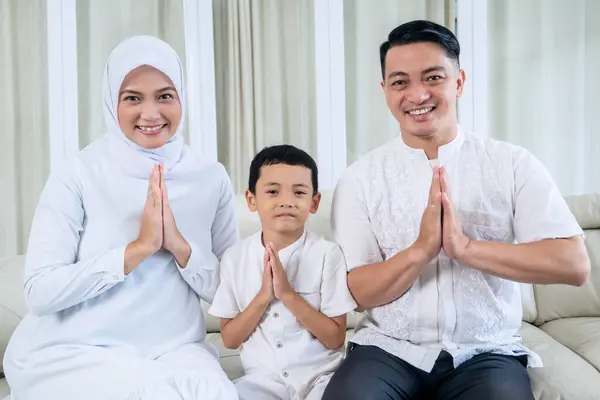 ムスリムの家族は リビングルームで手のジェスチャーイード ムバラクをお祝いします 自宅で撮影する — ストック写真