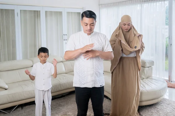 自宅のリビングルームで一緒に祈る若いイスラム教徒の家族 — ストック写真