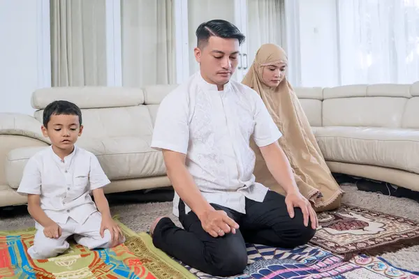年轻的穆斯林家庭一起在家里的客厅里祈祷 — 图库照片
