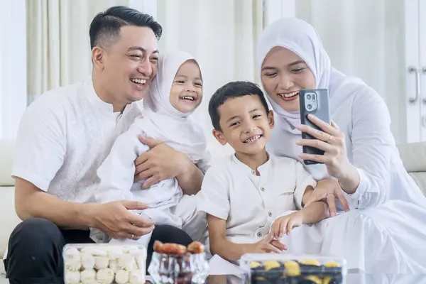 Szczęśliwa Muzułmańska Rodzina Wykonująca Rozmowę Wideo Lub Robiąca Sobie Selfie — Zdjęcie stockowe