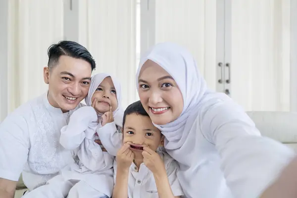 快乐的穆斯林家庭一起在沙发上打电话或自拍 — 图库照片