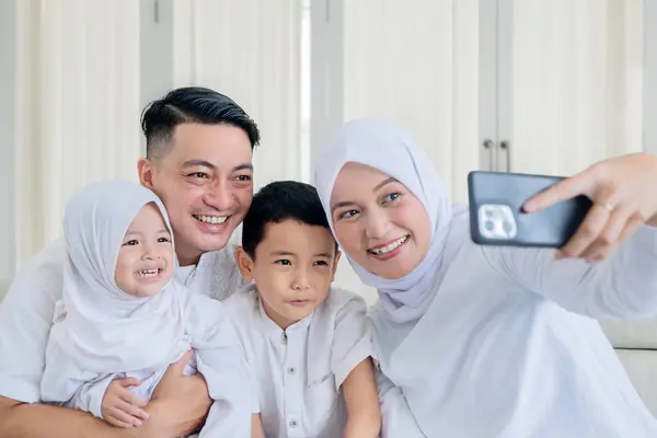 Familia Musulmana Feliz Haciendo Una Videollamada Tomando Una Selfie Mientras Imágenes de stock libres de derechos