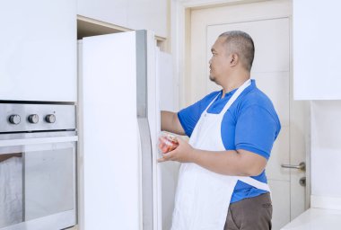 Önlüklü Adam Modern Mutfakta Dolapta Taze Malzemeler Depoluyor