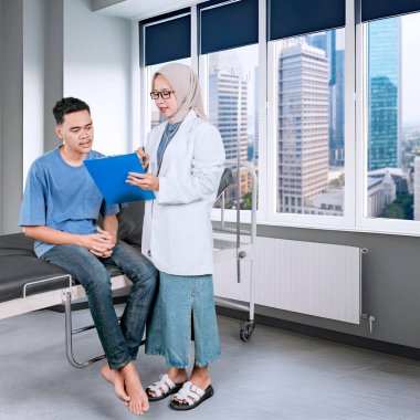 Kadın Müslüman Doktor Modern Tıp Ofisinde Erkek Hastaya Danışmanlık Yapıyor