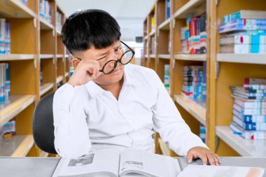 Kütüphanede Yorgun İfadeyle Karmaşık Öğrenci Çalışması