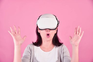 Videolar kullanan Asyalı bir kadın, sanal gerçeklik kulaklığından video oyunu oynayan, video teknolojisi ile yeni deneyimi olan genç bir kadın, Stüdyo çekimi..