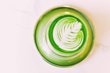 Matcha latte with latte art, A cup of japanese green tea in cafe, Healthy anti-aging drink.
