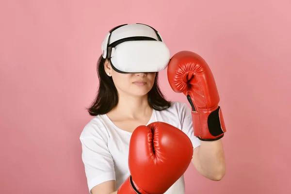 Asian woman using vr glasses, Working out with boxing video games application from virtual reality headset, Young woman enjoy new fitness experience by vr technology, Studio shot.