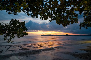 Dramatik bulutlar ve mavi ve turuncu renkli gökyüzü ile güzel bir gün batımı. Ao Nang plajı, Yengeç kasabası, Tayland.