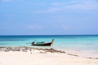 Ko Phi Phi, Tayland 'daki tropik plaj yakınlarında uzun kuyruklu tekneler. Beyaz kum ve turkuaz suyu olan tropik plaj, cennette tatil kavramı..