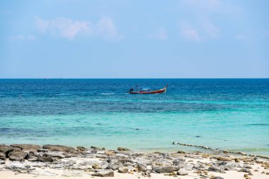 Ko Phi Phi, Tayland 'daki tropik plaj yakınlarında uzun kuyruklu tekneler. Beyaz kum ve turkuaz suyu olan tropik plaj, cennette tatil kavramı..