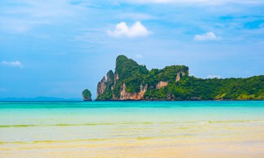 Tayland 'daki Ko Phi Adaları' ndaki kireçtaşından kaya ve teknelerle kıyı şeridi manzarası. Egzotik tropikal tatil kavramı ve cennetteki güzel doğa.