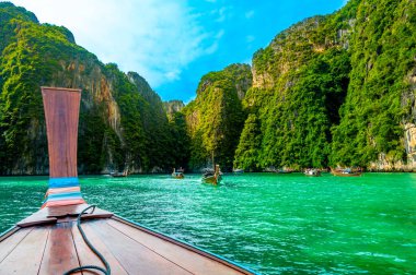 Tayland 'daki Ko Phi Phi adalarındaki Pi Leh lagününün (Yeşil Göl olarak da bilinir) manzarası. Tipik uzun kuyruklu teknenin görüntüsü. Tipik Tayland tropik cennet resmi. Kireç taşı kaya ve turkuaz su.