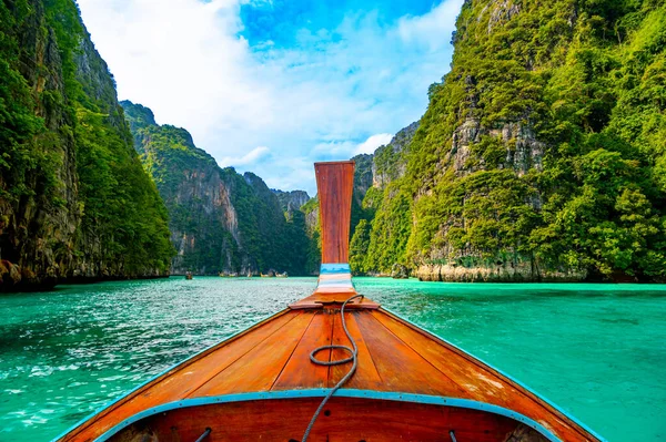 Tayland 'daki Ko Phi Phi adalarındaki Pi Leh lagününün (Yeşil Göl olarak da bilinir) manzarası. Tipik uzun kuyruklu teknenin görüntüsü. Tipik Tayland tropik cennet resmi. Kireç taşı kaya ve turkuaz su.