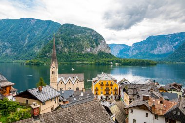 Hallstatt şehrinin ünlü panoraması. Hallstatter yakınlarında tipik bir kilise var. Gökyüzünde dramatik bulutlar. Avusturya 'nın ünlü turizm beldesi.