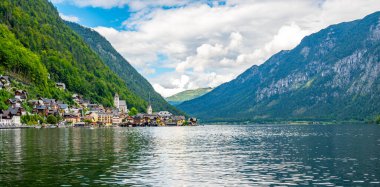Hallstatt şehrinin ünlü panoraması. Hallstatter yakınlarında tipik bir kilise var. Gökyüzünde dramatik bulutlar. Avusturya 'nın ünlü turizm beldesi.