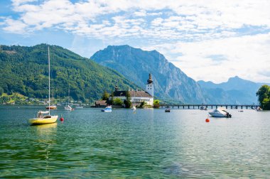 Avusturya, Traunsee yakınlarındaki Schloss Ort kalesi. Göl üzerinde uzun köprüsü olan antik bir kale manzarası. Ünlü turizm beldesi.