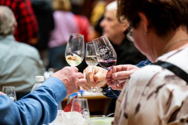 Hrusovany u Brna, Çek Cumhuriyeti - 17.2.2024: Şarap arıtma ve şarap tatma etkinliği. Bardaktan içen insanların görüntüsü. Güney Moravya bölgesi, Palava tepeleri yakınlarındaki şarap diyarı..