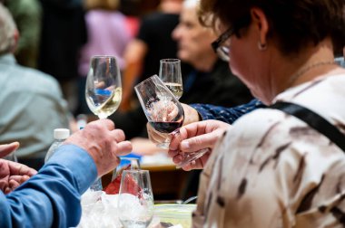 Hrusovany u Brna, Çek Cumhuriyeti - 17.2.2024: Şarap arıtma ve şarap tatma etkinliği. Bardaktan içen insanların görüntüsü. Güney Moravya bölgesi, Palava tepeleri yakınlarındaki şarap diyarı..