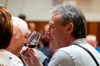 Hrusovany u Brna, Çek Cumhuriyeti - 17.2.2024: Şarap arıtma ve şarap tatma etkinliği. Bardaktan içen insanların görüntüsü. Güney Moravya bölgesi, Palava tepeleri yakınlarındaki şarap diyarı..