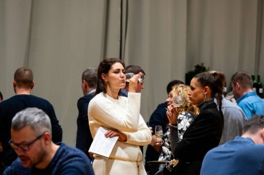 Hrusovany u Brna, Çek Cumhuriyeti - 17.2.2024: Şarap arıtma ve şarap tatma etkinliği. Bardaktan içen insanların görüntüsü. Güney Moravya bölgesi, Palava tepeleri yakınlarındaki şarap diyarı..