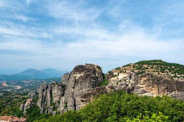 Manastır Meteora Yunanistan. Yaz panoramik manzara çarpıcı. Dağlar ve epik mavi gökyüzü bulutlu yeşil orman görüntüleyin. UNESCO miras listesi nesnesi.