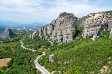 Manastır Meteora Yunanistan. Yaz panoramik manzara çarpıcı. Dağlar ve epik mavi gökyüzü bulutlu yeşil orman görüntüleyin. UNESCO miras listesi nesnesi.