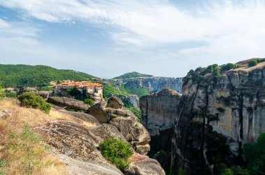 Monastery Meteora Greece. Stunning summer panoramic landscape. View at mountains and green forest against epic blue sky with clouds. UNESCO heritage list object. clipart