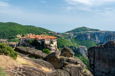 Manastır Meteora Yunanistan. Yaz panoramik manzara çarpıcı. Dağlar ve epik mavi gökyüzü bulutlu yeşil orman görüntüleyin. UNESCO miras listesi nesnesi.