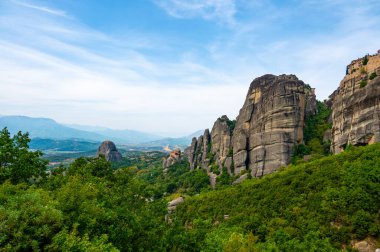 Manastır Meteora Yunanistan. Yaz panoramik manzara çarpıcı. Dağlar ve epik mavi gökyüzü bulutlu yeşil orman görüntüleyin. UNESCO miras listesi nesnesi.