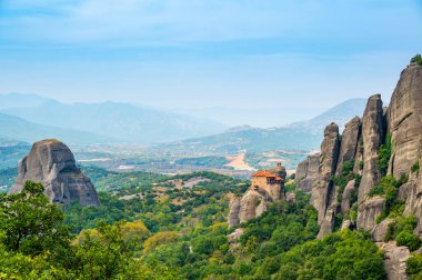 Manastır Meteora Yunanistan. Yaz panoramik manzara çarpıcı. Dağlar ve epik mavi gökyüzü bulutlu yeşil orman görüntüleyin. UNESCO miras listesi nesnesi.