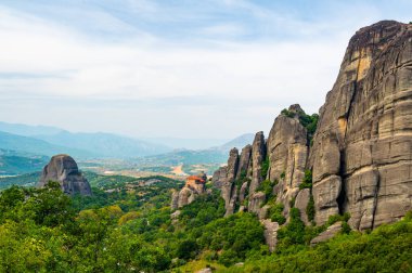 Manastır Meteora Yunanistan. Yaz panoramik manzara çarpıcı. Dağlar ve epik mavi gökyüzü bulutlu yeşil orman görüntüleyin. UNESCO miras listesi nesnesi.