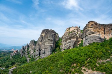 Manastır Meteora Yunanistan. Yaz panoramik manzara çarpıcı. Dağlar ve epik mavi gökyüzü bulutlu yeşil orman görüntüleyin. UNESCO miras listesi nesnesi.