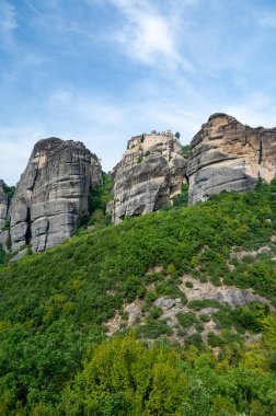 Manastır Meteora Yunanistan. Yaz panoramik manzara çarpıcı. Dağlar ve epik mavi gökyüzü bulutlu yeşil orman görüntüleyin. UNESCO miras listesi nesnesi.