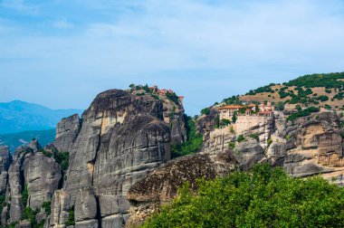 Manastır Meteora Yunanistan. Yaz panoramik manzara çarpıcı. Dağlar ve epik mavi gökyüzü bulutlu yeşil orman görüntüleyin. UNESCO miras listesi nesnesi.