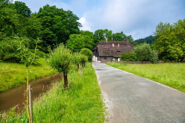 The Old Grandmother's House in Babiccino Valley is a charming historical cottage surrounded by lush greenery, blooming meadows, and the serene Upa River, embodying the essence of Bozena Nemcova's novel 