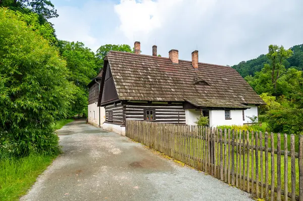 stock image The Old Grandmother's House in Babiccino Valley is a charming historical cottage surrounded by lush greenery, blooming meadows, and the serene Upa River, embodying the essence of Bozena Nemcova's novel 