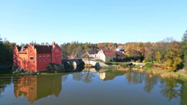Cervena Lhota Kalesi 'nin (Red Chateau, Schloss Rot) panoramik drone fotoğrafı, aşağıdaki göletteki kalelerin yansımasını gösteriyor. Sonbahar renkli ormanlarla çevrili