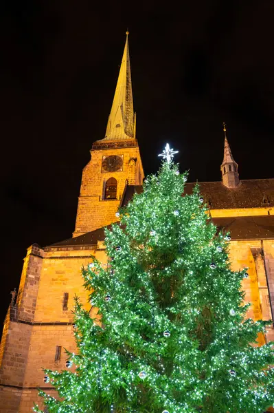 Ön planda Noel süsleri ve arkada Çek Cumhuriyeti 'nin Plzen kentindeki St. Bartholomew Katedrali' nin bulunduğu festival sahnesi. Gelenek ve tatil ruhunun büyüleyici bir karışımı.