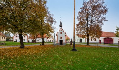 Medieval houses, farms, and granaries of Holasovice village in South Bohemia, arranged around a park with ponds. A UNESCO World Heritage Site showcasing rural baroque architecture clipart